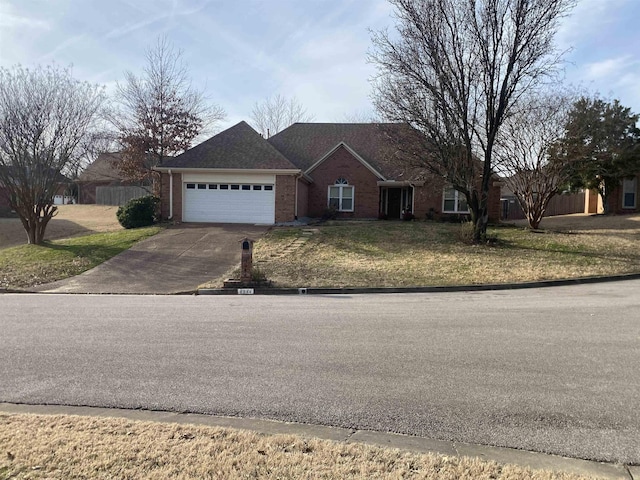 ranch-style house with a garage, driveway, a front yard, and brick siding