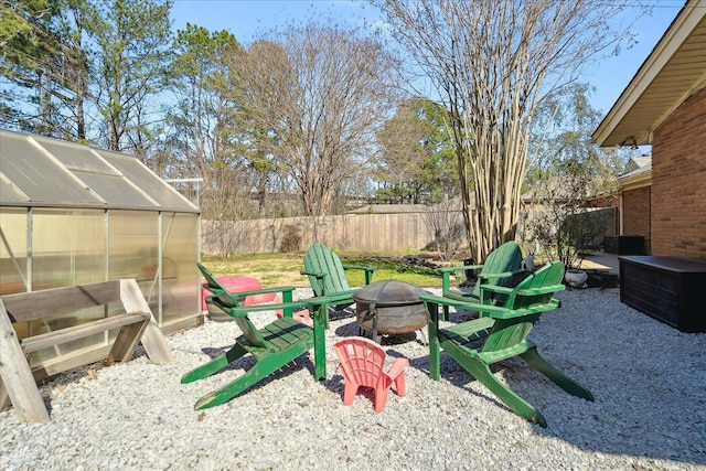 view of yard featuring a fire pit, an exterior structure, an outdoor structure, and fence