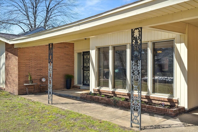 doorway to property featuring brick siding