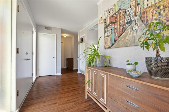 corridor with visible vents, baseboards, and wood finished floors