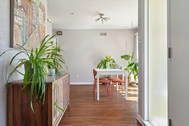 dining room with visible vents, baseboards, and wood finished floors