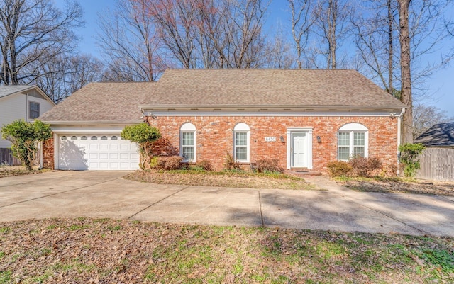 view of front of house with concrete driveway, brick siding, an attached garage, and fence