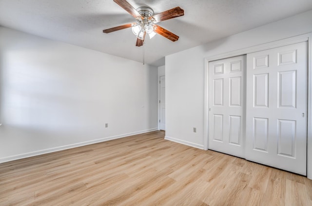 unfurnished bedroom with a ceiling fan, a closet, baseboards, and wood finished floors