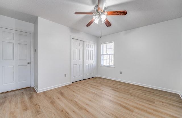 unfurnished bedroom with a closet, light wood-type flooring, a ceiling fan, and baseboards