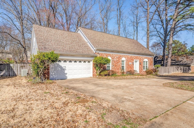 view of front facade featuring brick siding, a shingled roof, concrete driveway, fence, and a garage