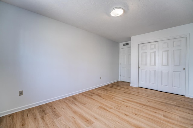 unfurnished bedroom featuring light wood-style floors, visible vents, and baseboards