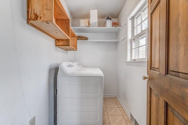 clothes washing area with laundry area, light tile patterned floors, baseboards, visible vents, and washer and dryer