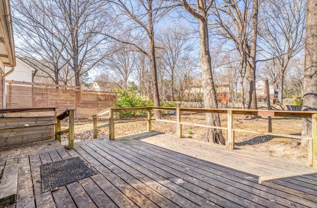 wooden terrace with a fenced backyard