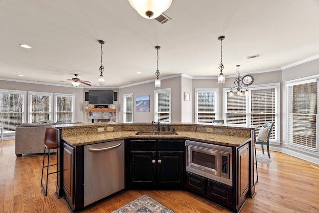 kitchen with visible vents, open floor plan, stainless steel appliances, light wood-style floors, and a sink