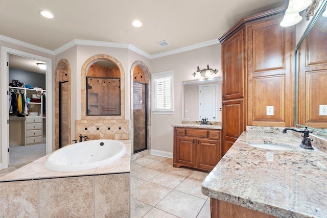 bathroom featuring tile patterned flooring, vanity, ornamental molding, a shower stall, and a tub with jets