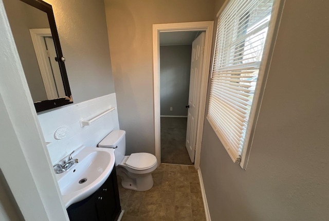 half bathroom with vanity and toilet