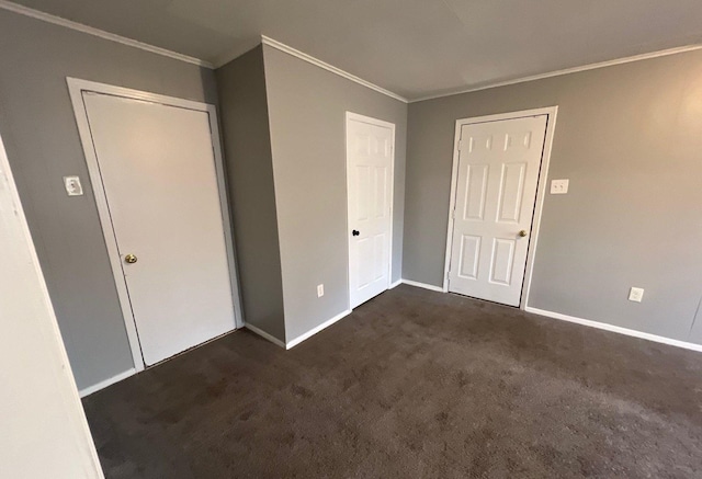 unfurnished bedroom featuring ornamental molding, dark carpet, and baseboards