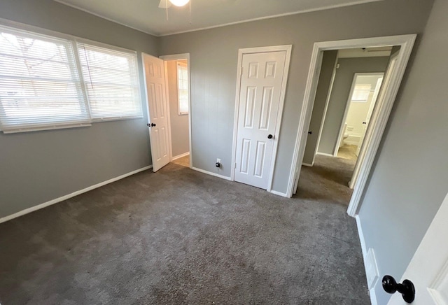 unfurnished bedroom with a closet, carpet flooring, and baseboards