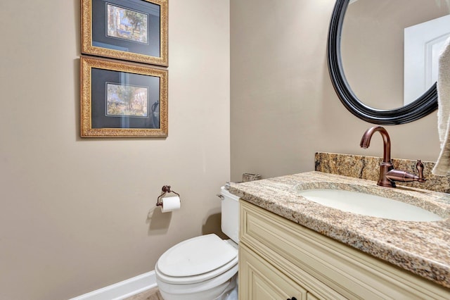 bathroom with vanity, toilet, and baseboards