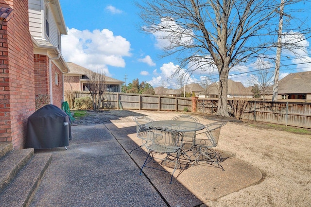 view of patio / terrace with outdoor dining area, a fenced backyard, and a grill