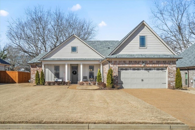 view of front of house featuring driveway, a garage, fence, a porch, and brick siding