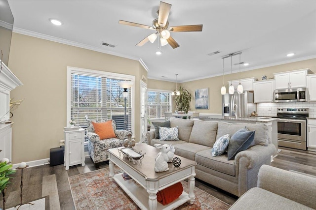 living room with crown molding and wood finished floors