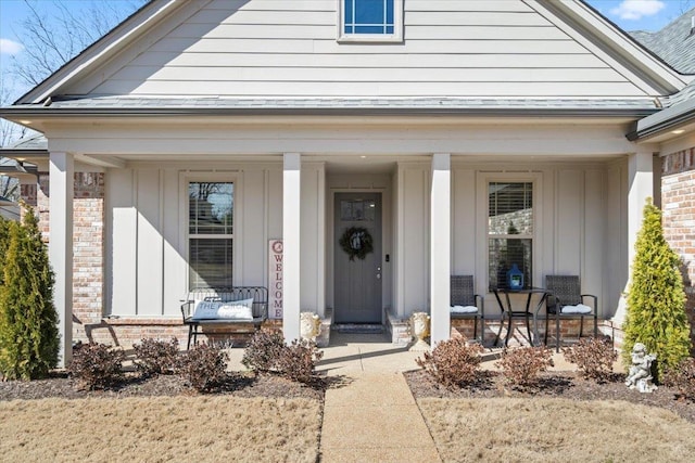 entrance to property with covered porch and brick siding