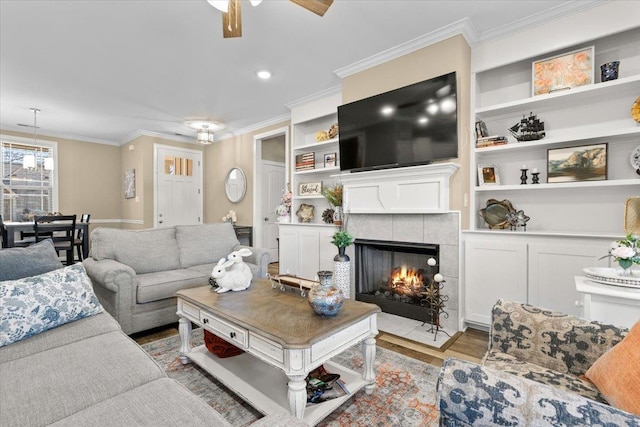 living area featuring built in features, crown molding, and wood finished floors