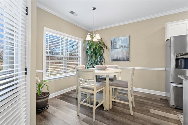 dining area featuring baseboards, dark wood finished floors, and crown molding