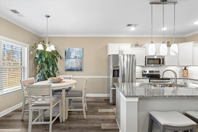 kitchen with visible vents, appliances with stainless steel finishes, tasteful backsplash, and ornamental molding