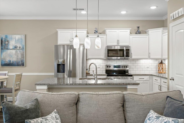 kitchen with tasteful backsplash, white cabinetry, stainless steel appliances, and a sink