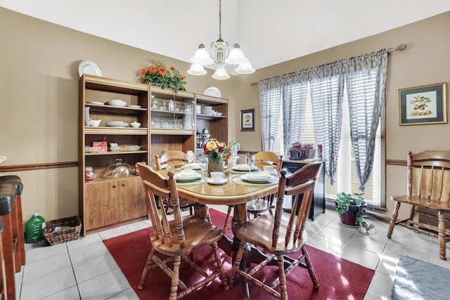 dining space featuring light tile patterned floors, a chandelier, and vaulted ceiling