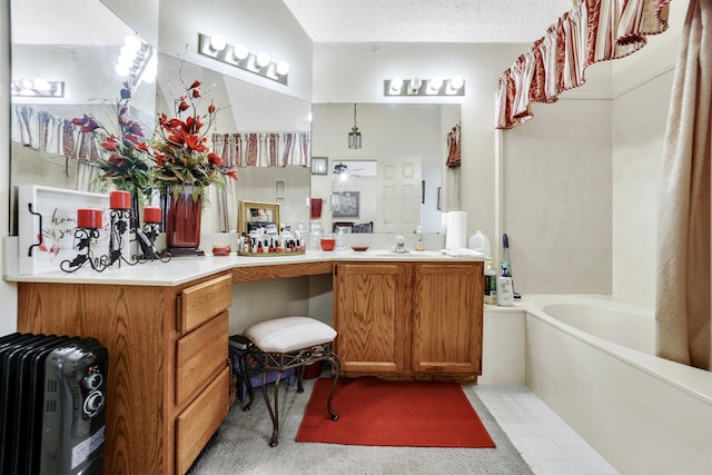 bathroom featuring tile patterned flooring, a textured ceiling, vanity, and a bath