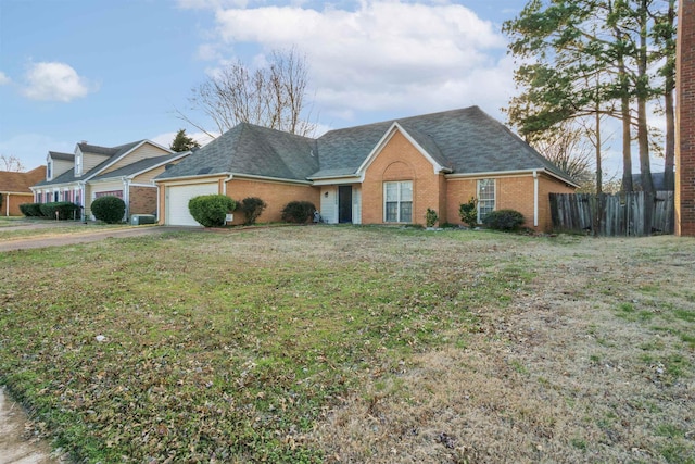 view of front of property featuring brick siding, an attached garage, fence, and a front yard