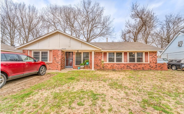 single story home featuring brick siding and a front yard