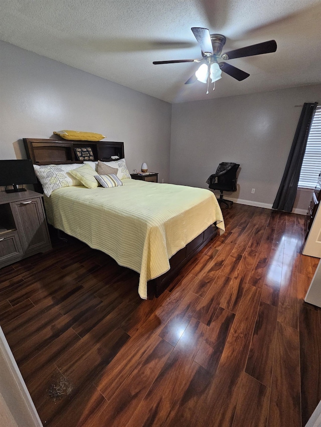 bedroom featuring dark wood-style floors, a textured ceiling, a ceiling fan, and baseboards