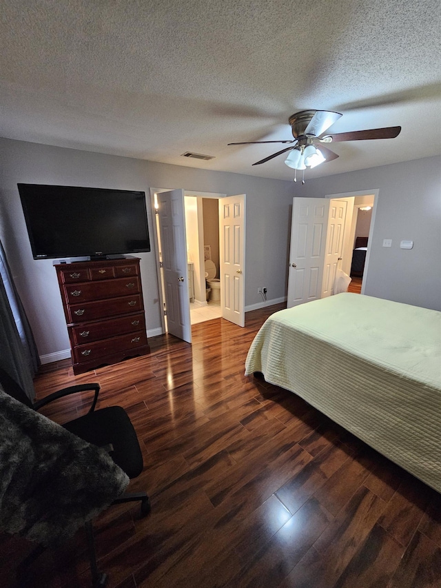 bedroom with a textured ceiling, ceiling fan, wood finished floors, visible vents, and baseboards