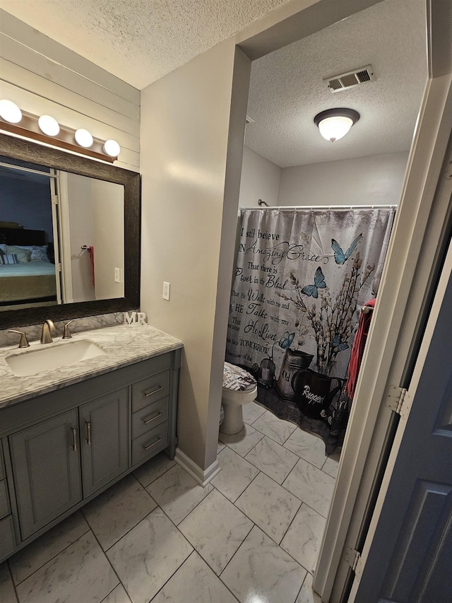 bathroom featuring toilet, wood walls, vanity, visible vents, and marble finish floor