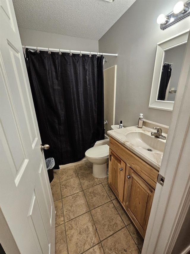 bathroom featuring a textured ceiling, toilet, a shower with shower curtain, and vanity