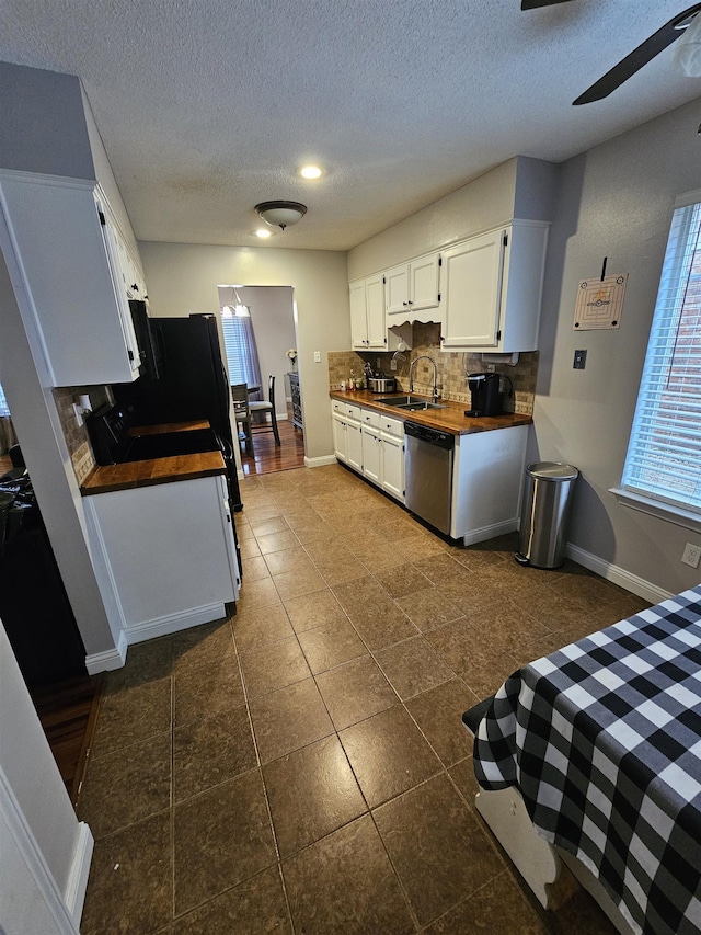 kitchen featuring ceiling fan, a sink, white cabinetry, decorative backsplash, and dishwasher