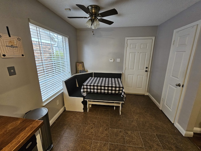 bedroom featuring a textured ceiling, a ceiling fan, and baseboards