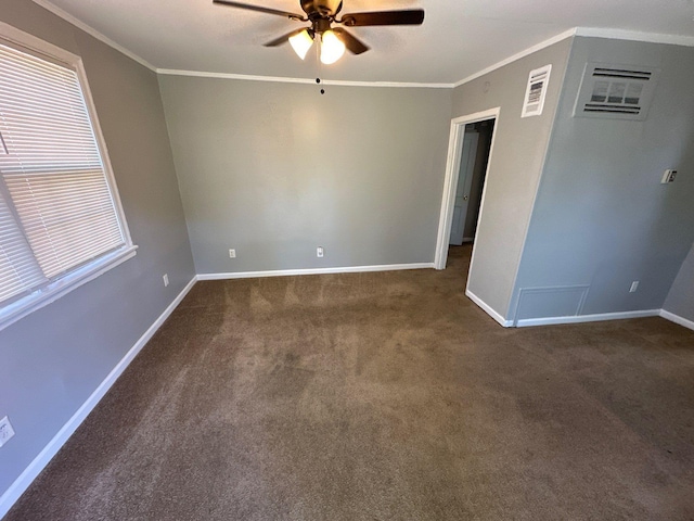 spare room with ceiling fan, dark colored carpet, ornamental molding, and baseboards