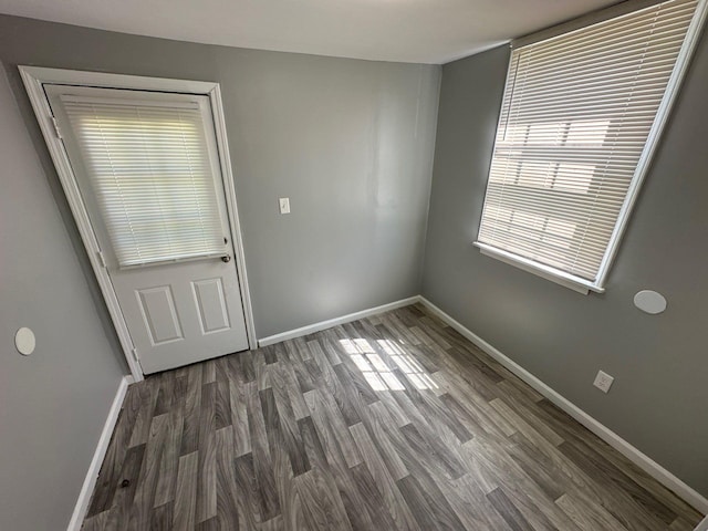 empty room with baseboards and wood finished floors