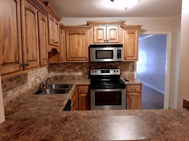 kitchen with stainless steel appliances, decorative backsplash, a sink, and crown molding