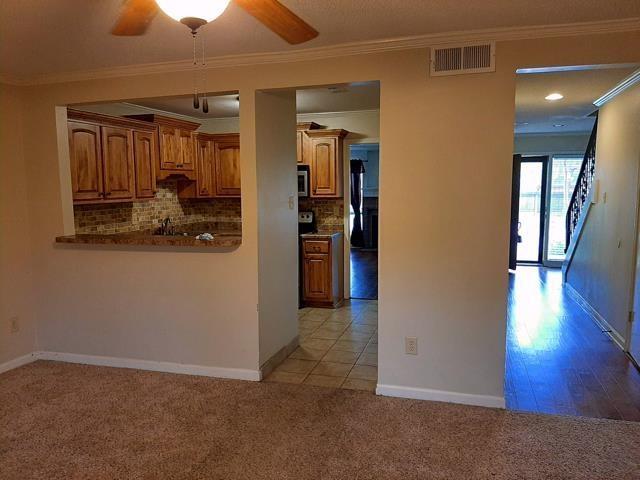 kitchen with ceiling fan, light carpet, visible vents, ornamental molding, and tasteful backsplash