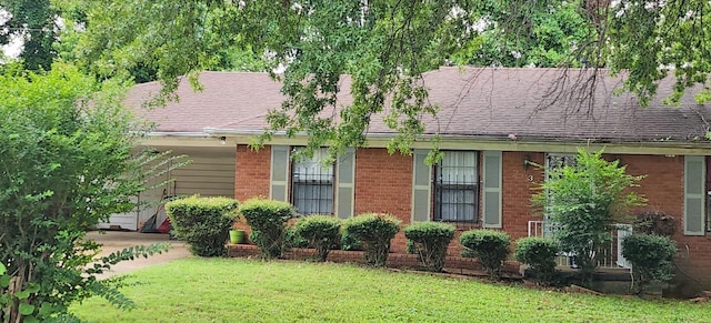 view of front of home with roof with shingles, a front lawn, and brick siding