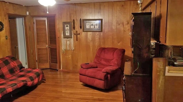 sitting room with light wood-style floors and wood walls