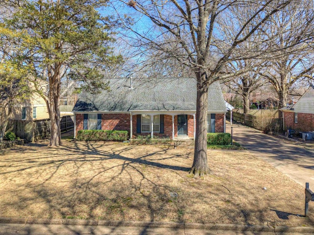 ranch-style home featuring brick siding, a shingled roof, and fence