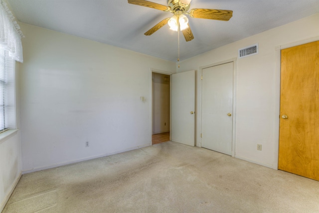 unfurnished bedroom featuring carpet, visible vents, ceiling fan, and baseboards