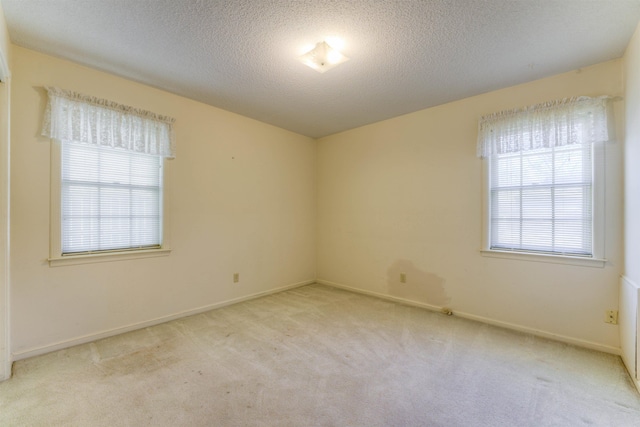 carpeted empty room featuring baseboards and a textured ceiling