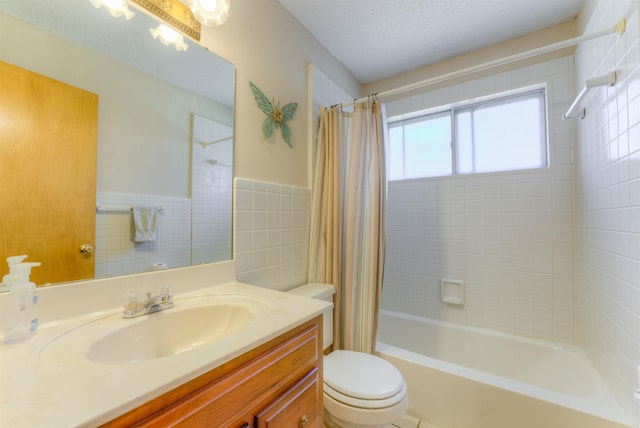 full bath featuring toilet, vanity, tile walls, wainscoting, and shower / tub combo with curtain