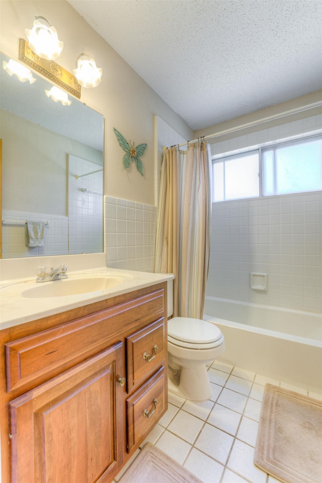 full bathroom with toilet, shower / tub combo with curtain, tile patterned floors, a textured ceiling, and vanity