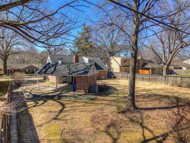 view of yard with a patio area, fence, and central AC unit