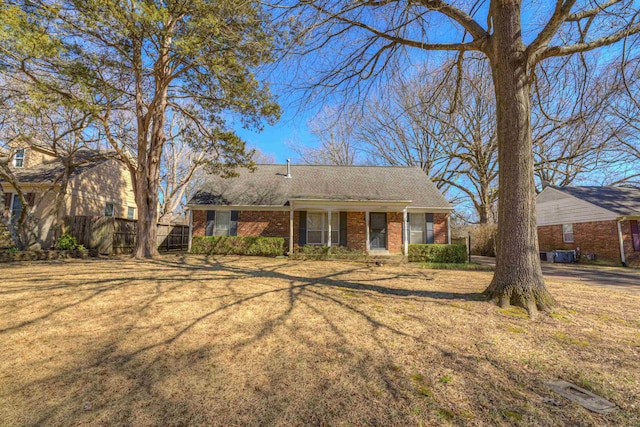 single story home featuring fence, a front lawn, and brick siding