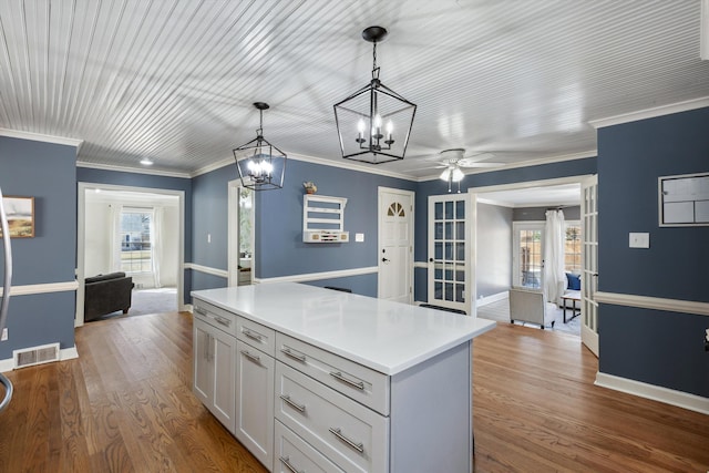 kitchen with plenty of natural light, wood finished floors, visible vents, and decorative light fixtures